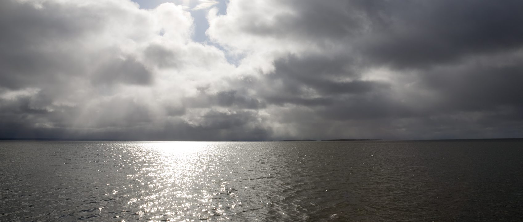 Wolken über dem Meer, die Sonne scheint hindurch, symbolisiert Müdigkeit, Erschöpfung, Depression